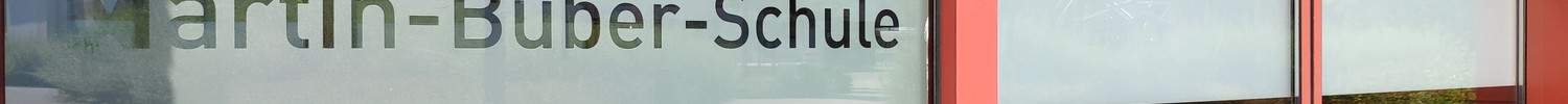 Eine automatische Schiebetür mit der Aufschrift "Martin-Buber-Schule". Dies ist der Haupteingang für die Schülerinnen und Schüler.